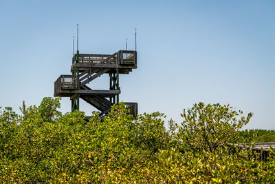 Low angle view of crane against clear blue sky