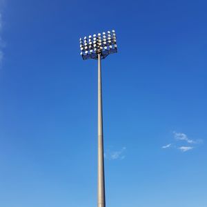 Spotlight pole standing against sky