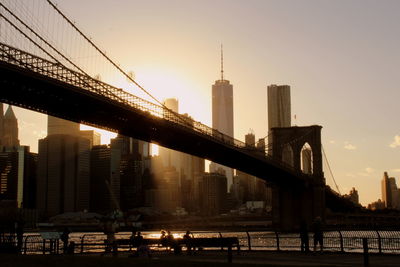 View of bridge and buildings against sky during sunset