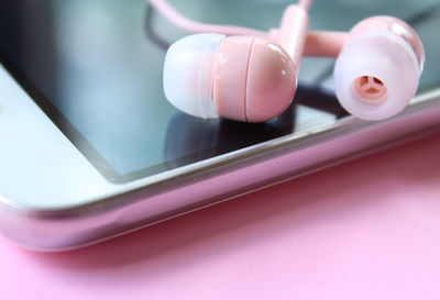 Close-up of mobile phone and headphones on table