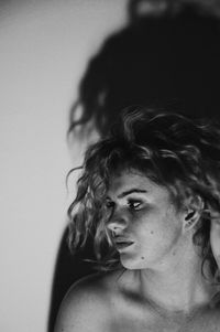 Close-up portrait of young woman against gray background