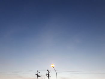 Low angle view of electricity pylon against clear sky