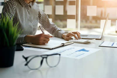 Midsection of business colleagues working on table