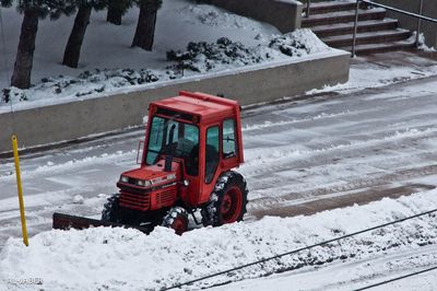 Snow covered land by road on field during winter