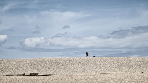 View of man walking at beach against sky