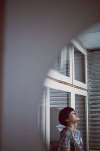 Young man seen through window
