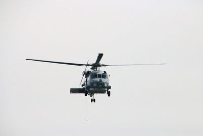 Low angle view of helicopter against clear sky
