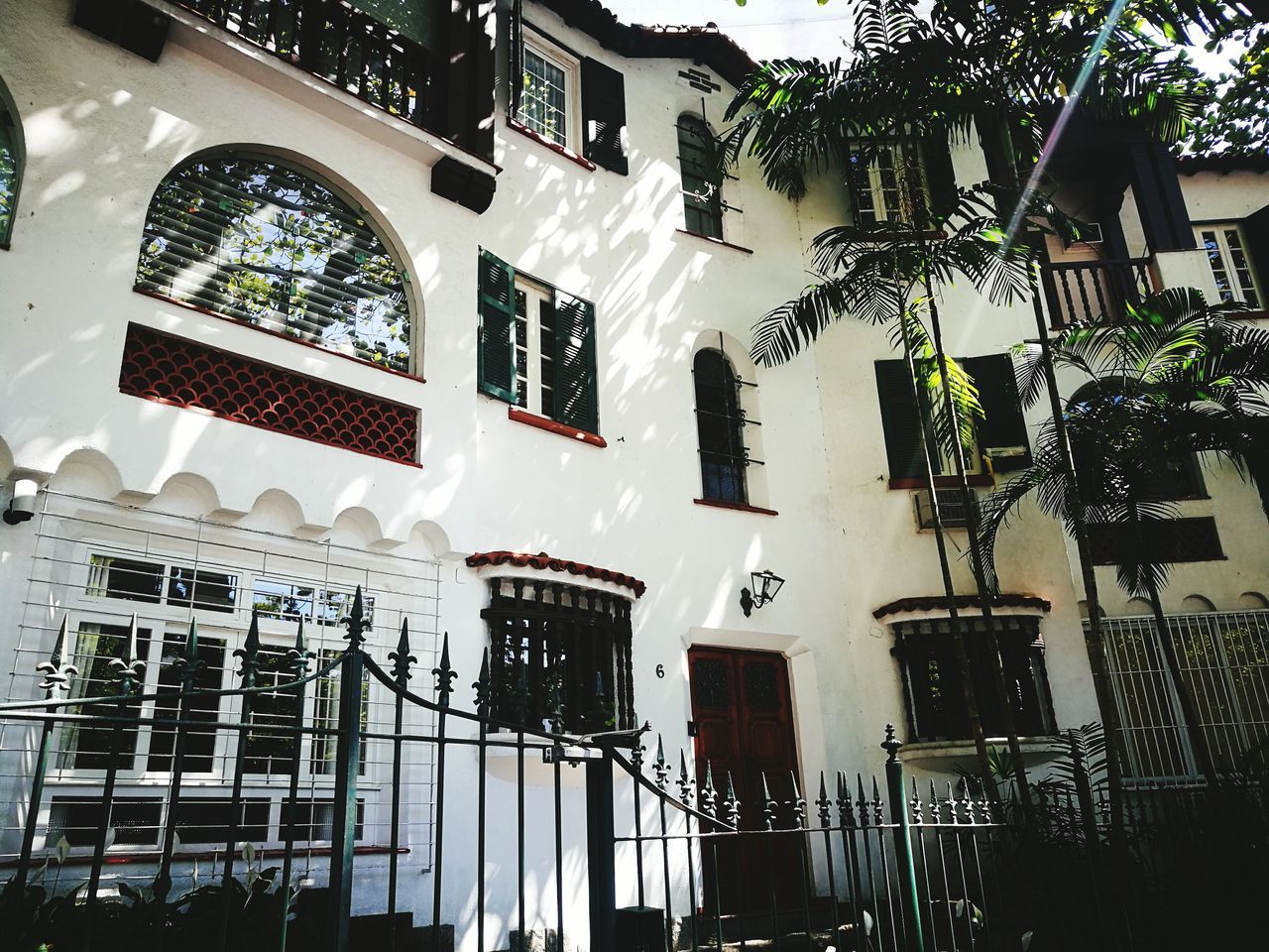 building exterior, architecture, built structure, building, low angle view, residential district, window, city, day, plant, outdoors, no people, tree, nature, lighting equipment, house, flag, hanging, balcony, street