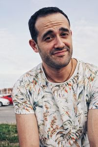 Portrait of young man standing against sky