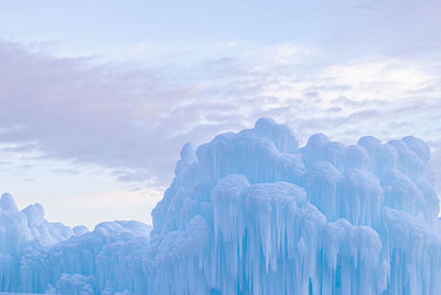 Scenic view of frozen ice castles landscape against sky