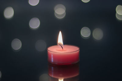 Close-up of lit candles in darkroom