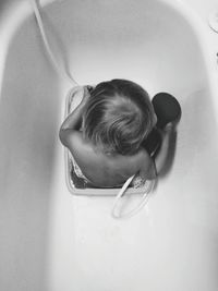 High angle view of baby sitting in bathtub