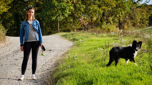 Portrait of woman with dogs on grassy field