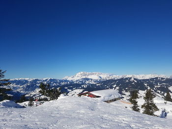 Scenic view of snowcapped mountains against clear blue sky