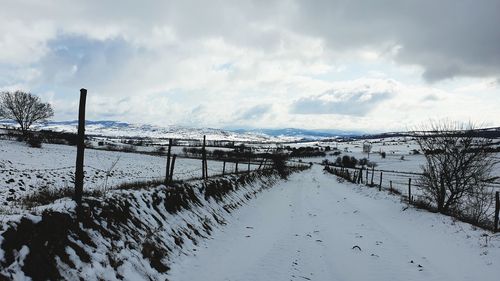 Scenic view of snowcapped field against sky