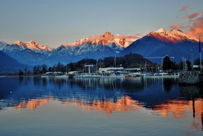 Scenic view of lake by mountains against sky during sunset