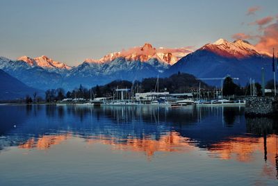 Scenic view of lake by mountains against sky during sunset