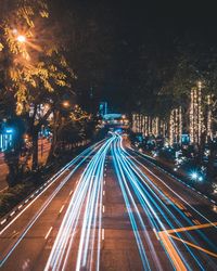 High angle view of light trails on road in city at night