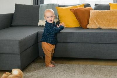 Low section of woman sitting on sofa at home