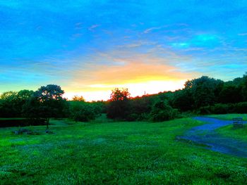 Scenic view of grassy field against cloudy sky