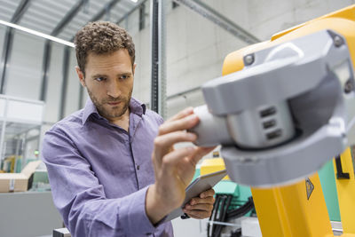 Technician adjusting industrial robot