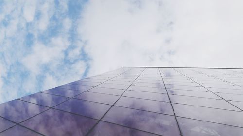 Low angle view of modern building against cloudy sky