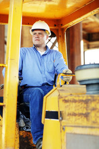 Male construction foreman sitting in a construction loader