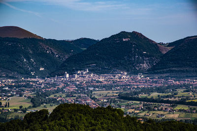 Aerial view of townscape and mountains against sky