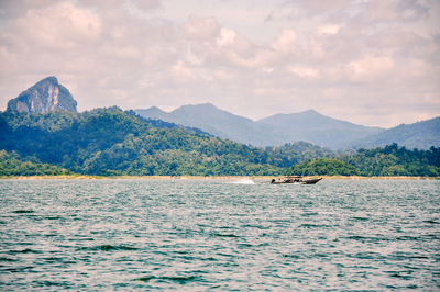 Scenic view of sea and mountains against sky