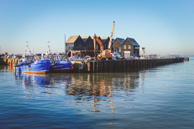 View of ship in sea against clear blue sky