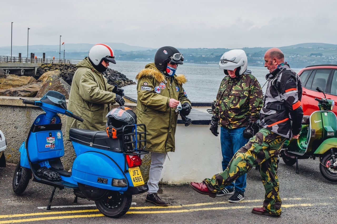 group of people, transportation, real people, mode of transportation, water, sea, men, occupation, helmet, sky, people, day, nature, headwear, rear view, road, clothing, land vehicle, group, outdoors, uniform, government, responsibility, crash helmet