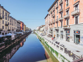 Canal amidst buildings in city against clear sky