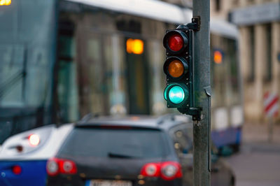 A city crossing with a semaphore on blurred background with cars in the evening streets, green light