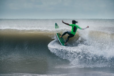 Man surfing in sea against sky