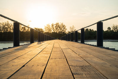 Surface level of footbridge over footpath by water against sky