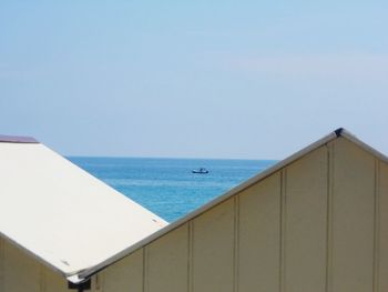 Huts by sea against sky