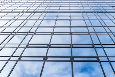 Low angle view of glass building against sky