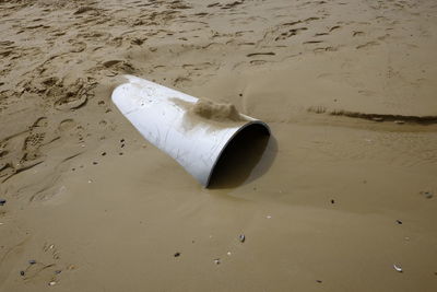 High angle view of pipe in wet sand at beach