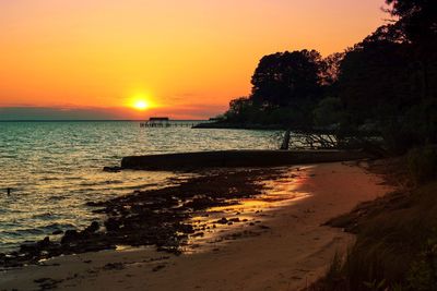 Scenic view of beach against clear sky during sunset