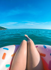 Girls legs on a swim tube in the black sea