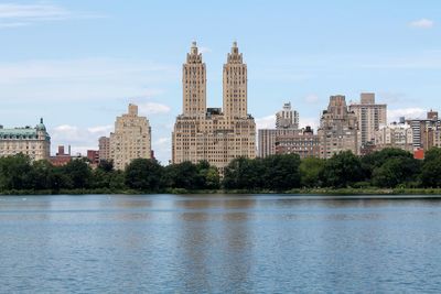 Buildings against cloudy sky at the jackeline kennedy onassis reservoir, in central park nyc. 