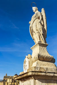 Low angle view of statue against blue sky