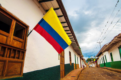 Colombian flag on residential building against cloudy sky