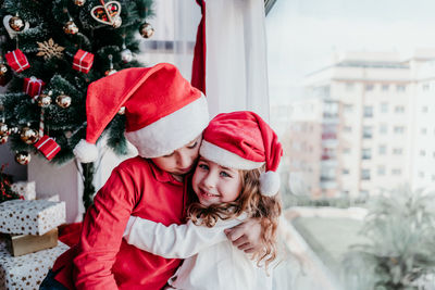 Smiling siblings at home during christmas