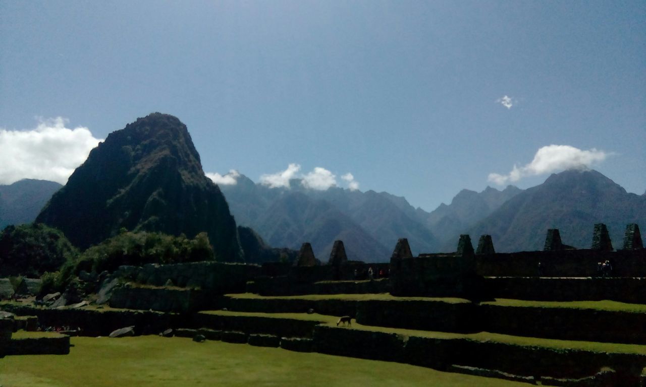 mountain, mountain range, sky, tranquil scene, tranquility, scenics, landscape, beauty in nature, built structure, water, nature, architecture, cloud - sky, lake, building exterior, cloud, river, outdoors, day, idyllic