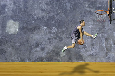 Side view of man jumping in swimming pool