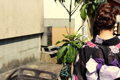 Rear view of woman standing by plants