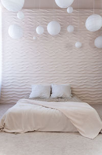 Minimalist bedroom with wavy wall design, natural light from the side window. serene sleeping space