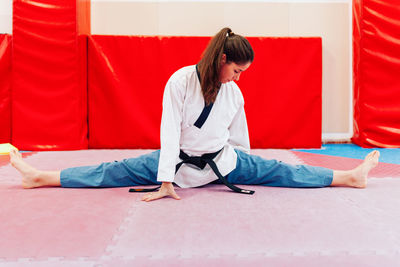 Full length of woman stretching on floor