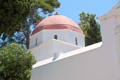 Low angle view of trees and building against sky